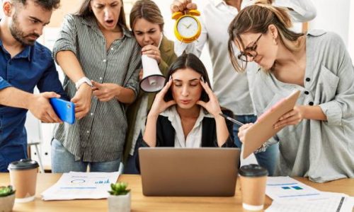 Group of business workers screaming to stressed partner at the office.